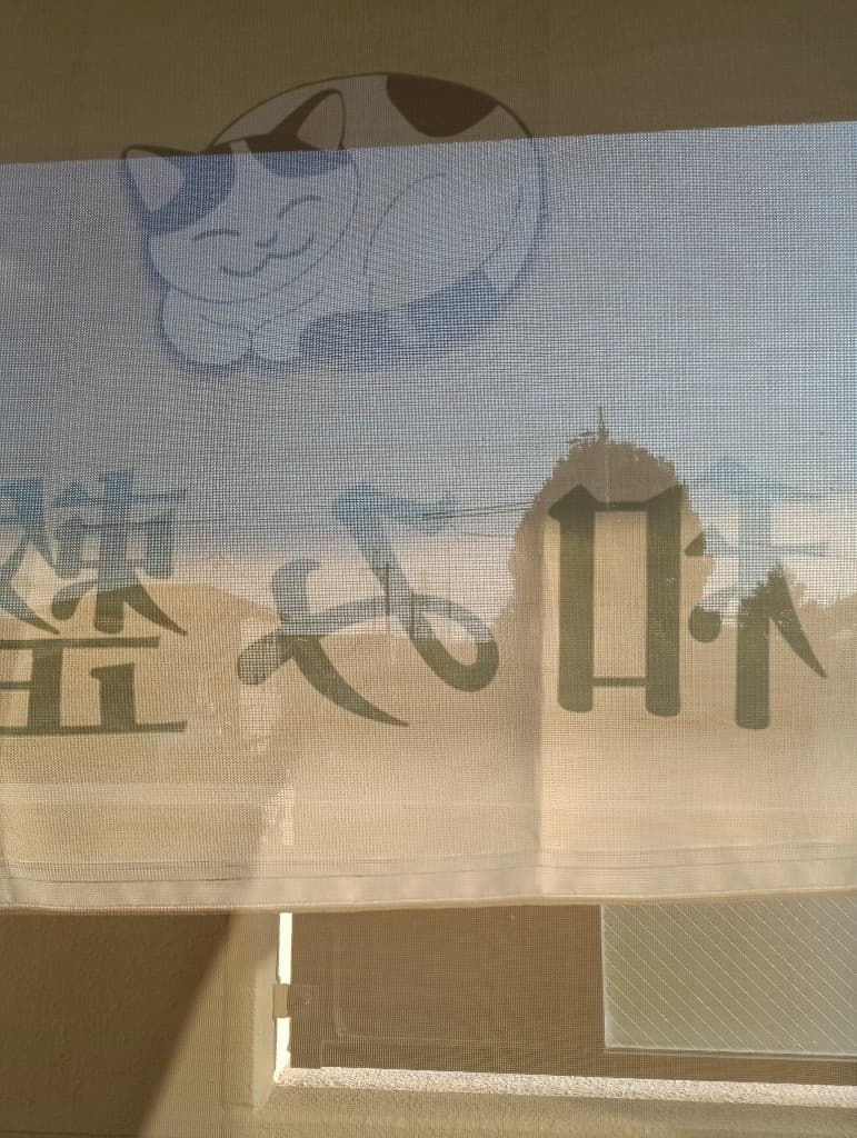 院内から見える横幕と近くの神社の木の風景